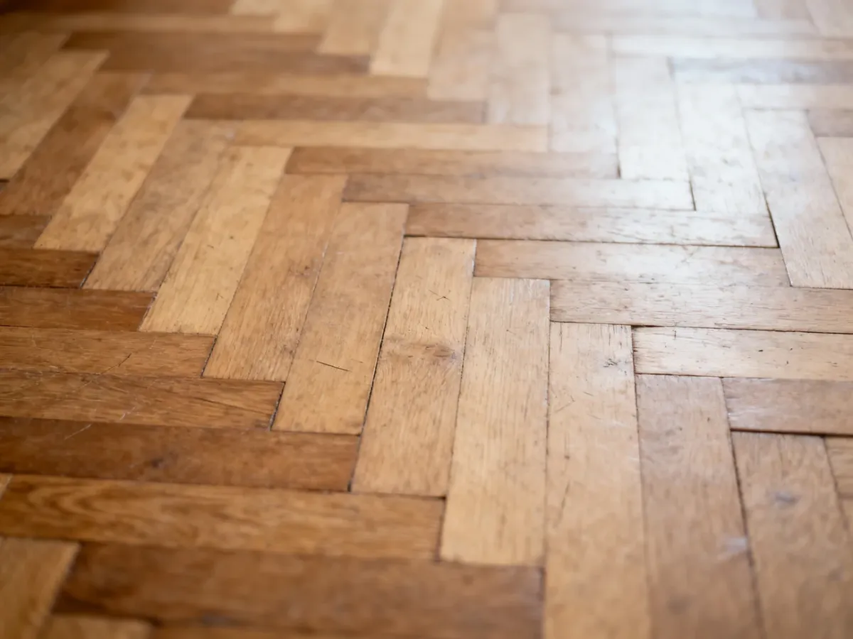 Stabilny stary parkiet z drobnymi rysami i zmatowiałą powierzchnią